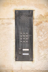 Close up view of an intercom system set into a stone wall
