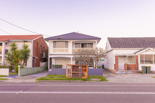 Old TV cabinet for giveaway on nature strip in front of homes on urban street