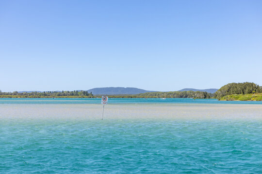 4 knots per hour sign in vibrant blue ocean water at Tuncurry, NSW Australia