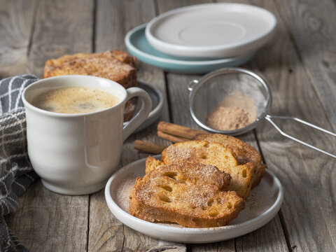 Coffee with milk accompanied by delicious homemade torrijas with sugar and cinnamon. rustic atmosphere