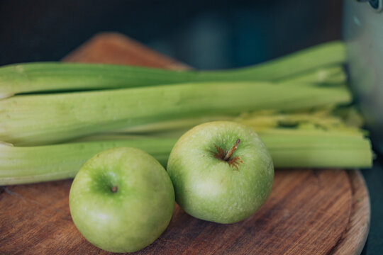 Green apples and celery close up on chopping board