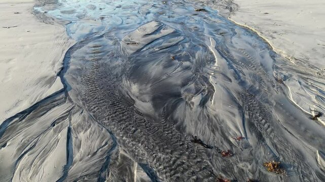 Natural watercourse, also known as a tidal creek, at Skagsanden Beach in Flakstad. Lofoten district in Norway 
