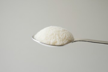 Powdered substance resting in a silver spoon.