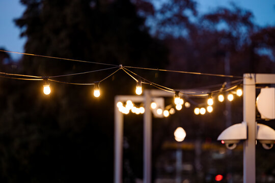 String of lights in the city with CCTV cameras in background