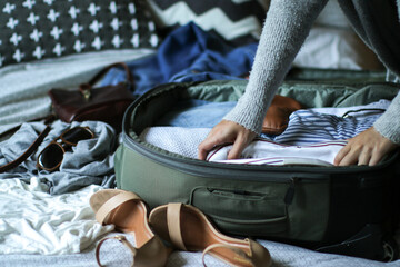 Young woman packing her bag ready to travel