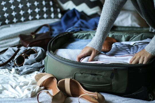 Young woman packing her bag ready to travel