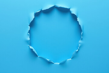 A blue sheet of paper torn in the shape of a circle with a blue backing and a place for text in the center of the circle.