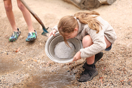 Kids panning for gold in shallow creek