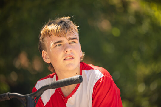 Close up portrait of teenage boy sitting with scooter