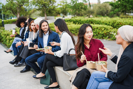Business people doing lunch break with healthy food outdoor from office building - Colleagues day lifestyle and food concept concept - Focus on asian girl face
