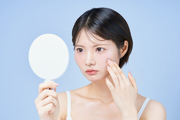 肌の様子を確かめる若い女性