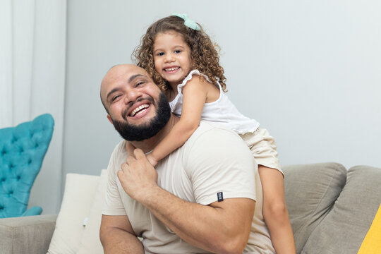pai e filha dando risada no sof&aacute; 