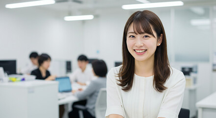  オフィスで働くスーツ姿の笑顔の30代女性