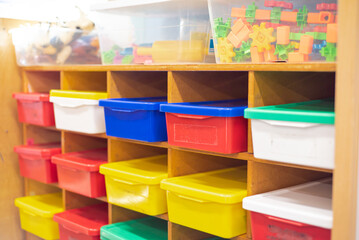 Kindergarten classroom organization with wooden building blocks, plastic connecting gear shapes,...