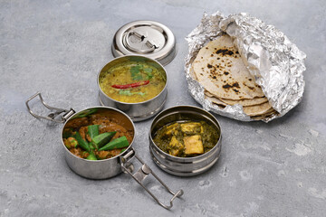 A retro Indian lunch box filled with vegetarian food.