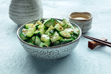 Smashed cucumber salad, healthy vegan food, green plant-based appetizer, shot with sake and chopsticks