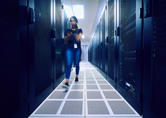 Female technician walking in server room 