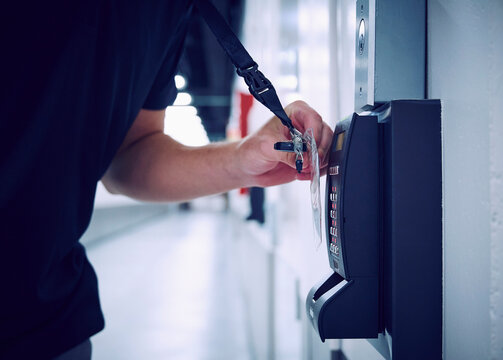 Close-up of employee using keycard and digital door lock in server room
