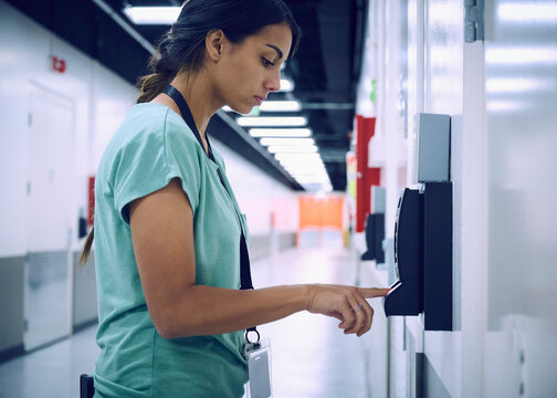 Woman using digital fingerprint scanner in office in server room
