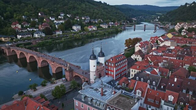 Aerial drone view of the Old Bridge (Alte Br&uuml;cke) in Heidelberg, Germany, capturing its historic charm, beautiful Baroque architecture, and breathtaking location spanning the Neckar River .