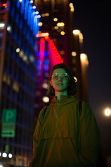 Fototapeta premium Portrait of young woman in neon city lights at night