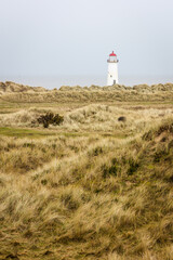 Lighthouse seen through sand dunes in winter