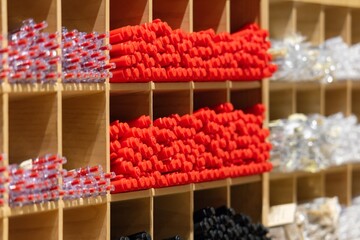 A wooden shelf with many different colored pens and pencils
