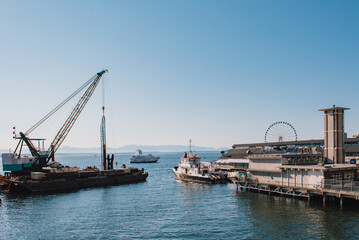 Obraz premium Seattle harbor with white ferris wheel on right in sunny day.