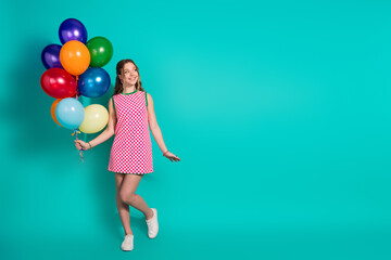 Fototapeta premium Full size photo of pretty teen girl hold air balloons look empty space wear trendy plaid pink outfit isolated on cyan color background