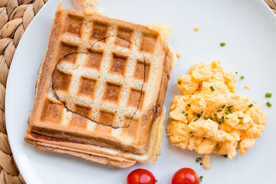 Delicious toast sandwich with eggs and cherry tomatoes on white plate