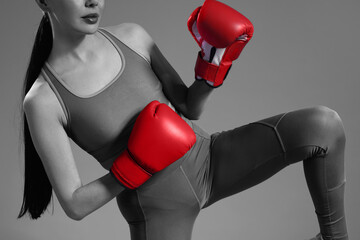 Woman in boxing gloves, closeup. Black-and-white toning with color accent