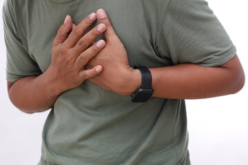 Close up photo of asian man feeling suffering and using hand for touching on chest for checking about his heart attack symptom , mental health care concept