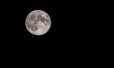 Off-set detail of a full moon against a black background