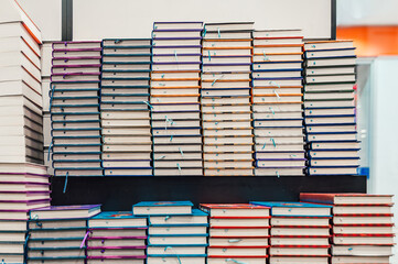 Stacked notebooks in a bookstore or library. Rows of journals in different colors. Education,...