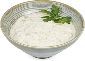 A warm bowl of delicious soup garnished with a sprig of parsley on top