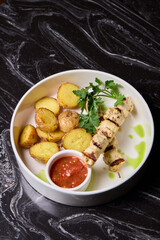 Delicious Grilled Chicken Skewers Served with Potatoes and Flavorful Sauce for Enjoyment