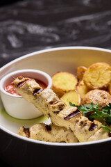 Delicious Grilled Chicken Skewers Served with Potatoes and Flavorful Sauce for Enjoyment