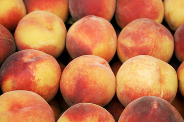 Whole fresh ripe peaches. Natural background, blur, selective focus. Organic fruits and berries at the farmers market.
