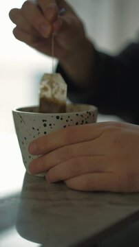 Tea capet in a cup close-up.
A man drinks tea during breakfast.
A man brews a tea bag in a cup.
Tea bag close-up in a cup