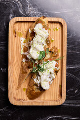 A Mouthwateringly Delicious Gourmet Dish Impeccably Served on a Rustic Wooden Plate