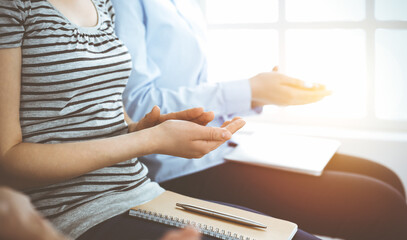 Business people clapping at meeting or conference, close-up of hands. Group of unknown businessmen and women in sunny office