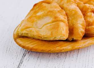 Freshly baked langos, savoury deep fried flat bread on wooden plate