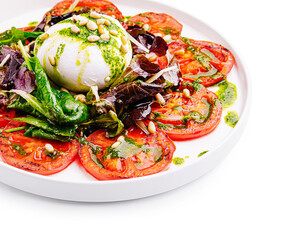 Fresh salad with mozzarella, tomatoes, and pesto dressing served