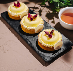 Lemon tartlets decorated with edible flowers on a serving platter