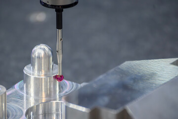 Close up scene the CMM probe measuring the aluminum automotive parts.