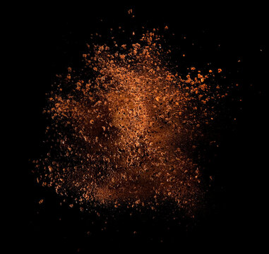Dry instant coffee explosion on black background, studio shot