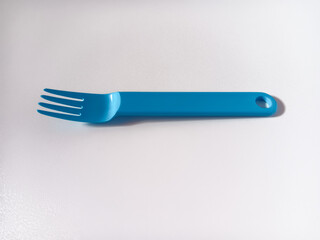 Close up of blue plastic fork isolated on white background.