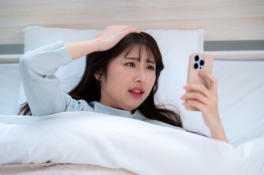 スマホを見て寝坊したことに気がついた日本人女性