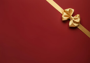 Elegant golden bow on red background with diagonal ribbon for gift or celebration