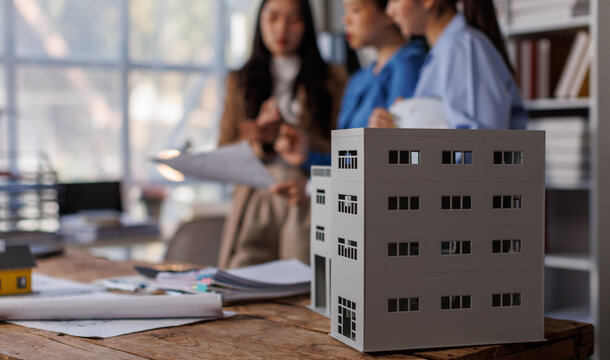 Business meetings of real estate brokers and mortgage engineering team to review blueprint to build a housing estate at office building project 